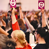 Delegates holding up cards